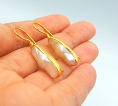 "Flat Fresh water Pearl, Drop Earrings made out of 18 karat Gold plated Sterling Silver. 100% Handmade Jewellery. PEARL: This enchanting June birthstone originates from oceans, lakes and rivers around the world. It is a timeless wardrobe staple, beloved by women of all ages. Pearls have long been associated with purity, humility and innocence. So it may be said that the June birthstone meaning is \"sweet simplicity.\" As such, pearls were traditionally given as a wedding gift. THE EARRINGS: We l High Luster Drop Pearl Earrings For Gift, High Luster Drop Earrings For Gift, Gift Yellow Gold Pearl Earrings With Gemstone, Yellow Gold Pearl Earrings With Gemstone For Gift, Gold Pearl Earrings With High Luster For Gift, Gold Pearl Gemstone Earrings For Anniversary, Fine Jewelry Earrings With High Luster For Gifts, Gold Earrings With High Luster For Gift, Gold Pearl Earrings With Gemstone For Formal Occasions