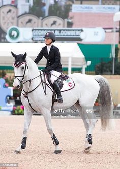 a woman riding on the back of a white horse