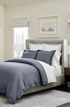 a bed with blue and white sheets in a bedroom