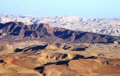 the mountains are covered in brown sand and snow capped peaks with no clouds on them