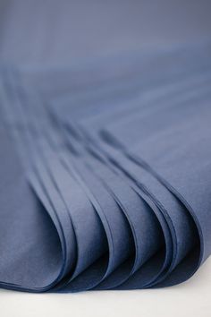 blue sheets folded on top of each other with white table in the backgroud