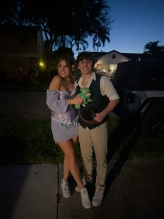 a man and woman standing next to each other in front of a truck at night