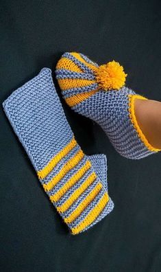 a pair of crocheted slippers with yellow and blue stripes