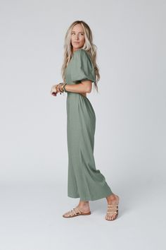 This flattering and feminine jumpsuit features a v-neckline, 3/4 length puff sleeves, an open back with a cute tie closure, and comfy wide pant legs. It's lightweight with a full lining and an elastic waistline making it comfy and easy to wear! Paired with a bralette such as our Tattoo Bralette would make an effortless springtime outfit!*Due to lighting and differences in monitors, actual colors may vary slightly from what appears online Model is 5'8" and wearing a size Small. Approximate measur Puff Sleeve Jumpsuit, Spring Time Outfits, Teacher Fits, Feminine Casual, Jumpsuit Casual, Family Picture Outfits, Green Jumpsuit, Chill Outfits, Family Pics