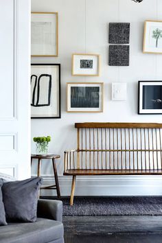 a living room filled with furniture and lots of framed pictures on the wall above it