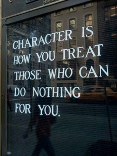 a sign on the side of a building that says character is how you treat those who can do nothing for you