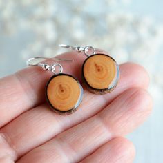 a pair of earrings made out of wood is shown in the palm of someone's hand