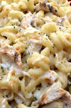 a close up view of a pasta dish with chicken and cheese on it's surface