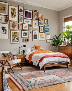 a bed room with a neatly made bed and lots of framed pictures on the wall