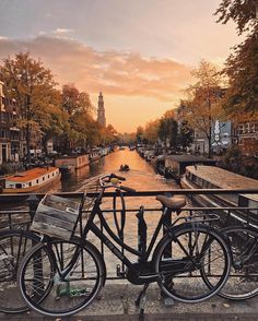 two bikes parked next to each other on the side of a bridge over a river