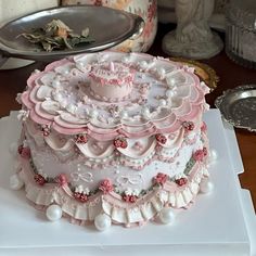 a three tiered cake with pink and white decorations