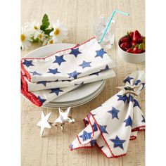 red, white and blue napkins with stars on them sitting next to a bowl of strawberries