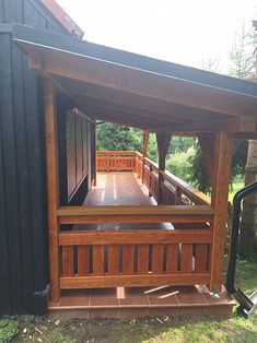 a wooden gazebo sitting on top of a lush green field