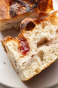 two pieces of bread sitting on top of a white plate next to another piece of bread