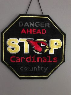 a black and yellow sign that says danger ahead, stop cardinals country on it