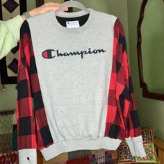 a person holding up a shirt with the word champion on it in front of a mirror