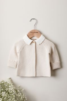 Made with exceptionally soft organic cotton, our Scallop Collar Baby Cardigan offers timeless beauty combined with cosy practicality. Knitted in our beautiful Oat melange with a milk-white scalloped knit collar, this stunning garter stitch cardigan is destined to become a treasured piece in your little one's wardrobe. Composition: GOTS-certified 100% Organic Cotton. Soft, safe, and gentle on your baby's skin. Our baby knitwear won the Prestigious Platinum Award for 'Best Organic Clothing Brand' Baby Trends, Scallop Collar, Knit Bonnet, Baby Knitwear, Gift Bundle, Baby Bundles, Baby Trend, Organic Baby Clothes, Collar Cardigan