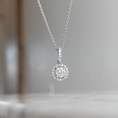 One (1) 18K White gold round diamond halo pendant prong set with (1) 48/100CT center diamond of fine (I) color and (SI1) clarity and (23) round brilliant cut diamond 18/100CTW of fine (G) color and (VS2) clarity. This necklace can be customized to fit your needs. Please give us a call at 314-548-5100 to have your custom order placed. **10K and 18K and larger stone sizes available by request. White Gold Round Diamond Necklace, White Round Halo Diamond Necklace, Diamond White Round Halo Necklace, Hallmarked Diamond White Necklace With Round Cut, White Halo Diamond Necklace With Round Pendant, Diamond White Hallmarked Round Pendant Necklace, Round Diamond Pendant, Halo Necklace, Halo Pendant