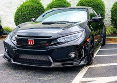 the front end of a black car parked in a parking lot