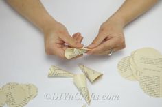 two hands are holding pieces of paper that have been folded into heart shapes with words written on them