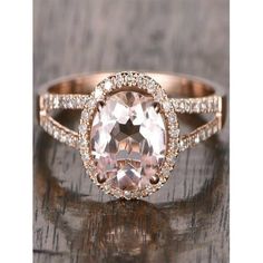 an oval shaped morganite and diamond ring on a wooden surface