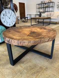 a wooden table with black metal legs in a room filled with furniture and clocks on the wall