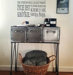 a metal table with two baskets on it and a wall sticker behind it that says, i love you