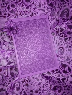 a purple book with an intricate design on it and a flower in the middle, surrounded by hearts