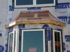 an image of a window being installed on the side of a house that is under construction