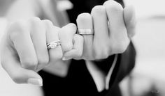 black and white photograph of a woman holding her engagement ring in one hand with the other