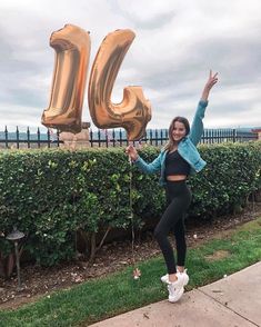 a woman posing in front of the number 50 balloon