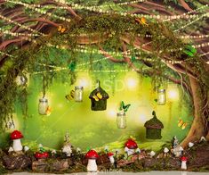 an image of a forest scene with fairy lights and mushrooms on the ground in front of a green background