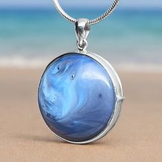 Introducing our exquisite Sterling Silver Leland Blue Locket Pendant, a perfect blend of beauty and elegance! This stunning locket features a genuine 23mm diameter Leland Blue stone set in high-quality Sterling Silver. The captivating foundry glass, born from the short-lived days of smelting by the Lake Superior Iron Company in Leland, Michigan, between 1875 and 1900, carries a unique and vibrant history. Wear this unique pendant close to your heart and embrace the essence of Michigan's geological heritage. Leland Blue, with its striking shades of blue, purple, or green, is a treasured symbol of the state, found along the scenic shores of Lake Michigan and Lake Huron. The locket's craftsmanship showcases the natural beauty of the stone, making it a timeless addition to your jewelry collect Blue Medallion Jewelry With Polished Finish, Blue Jewelry With Detachable Round Pendant, Blue Jewelry With Detachable Pendant, Blue Round Gemstone Jewelry, Blue Round Large Pendant Jewelry, Blue Large Round Pendant Jewelry, Blue Round Pendant Jewelry With Polished Finish, Blue Medallion Jewelry For Gifts, Blue Round Pendant Necklace With Polished Finish