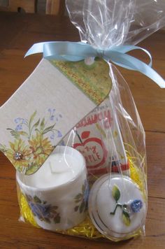 a gift bag filled with tea cups and saucers on top of a wooden table