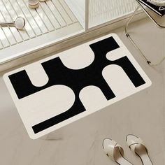 a black and white rug on the floor next to shoes