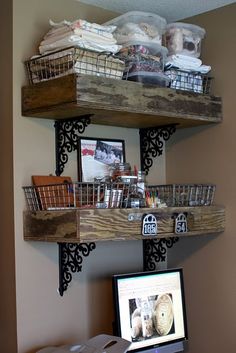 two wooden shelves with baskets on them above a computer