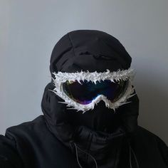 a person wearing ski goggles with white feathers on them