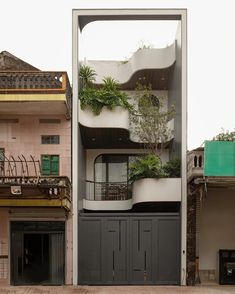 an apartment building with plants growing on the balconies