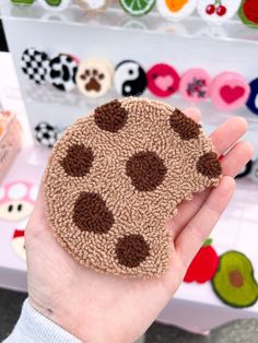 a person holding up a small piece of fabric with brown and white dots on it