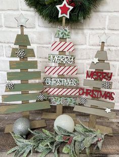 wooden christmas trees on display in front of a brick wall