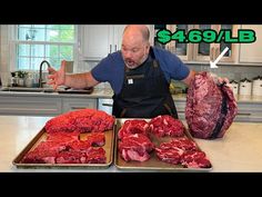 a man standing in front of two trays filled with raw meat on top of a kitchen counter