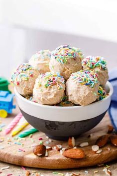 a bowl filled with cake batter and sprinkles on top of a wooden cutting board