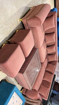 an upholstered pink couch and chair in a room with blue boxes on the floor