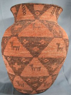 a brown and black vase sitting on top of a blue cloth covered table next to a white wall