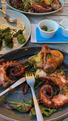 an assortment of food is on a plate with utensils and plates next to it