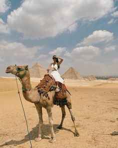 a woman riding on the back of a camel