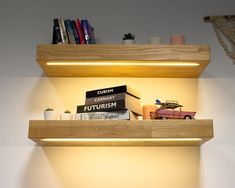 two wooden shelves with books on top of them and a toy car in the middle