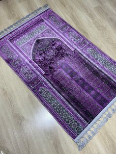 a purple rug is on the floor in front of a wooden floor