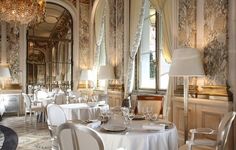 a fancy dining room with white tables and chairs