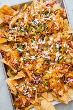 a tray filled with nachos covered in cheese and toppings on top of it